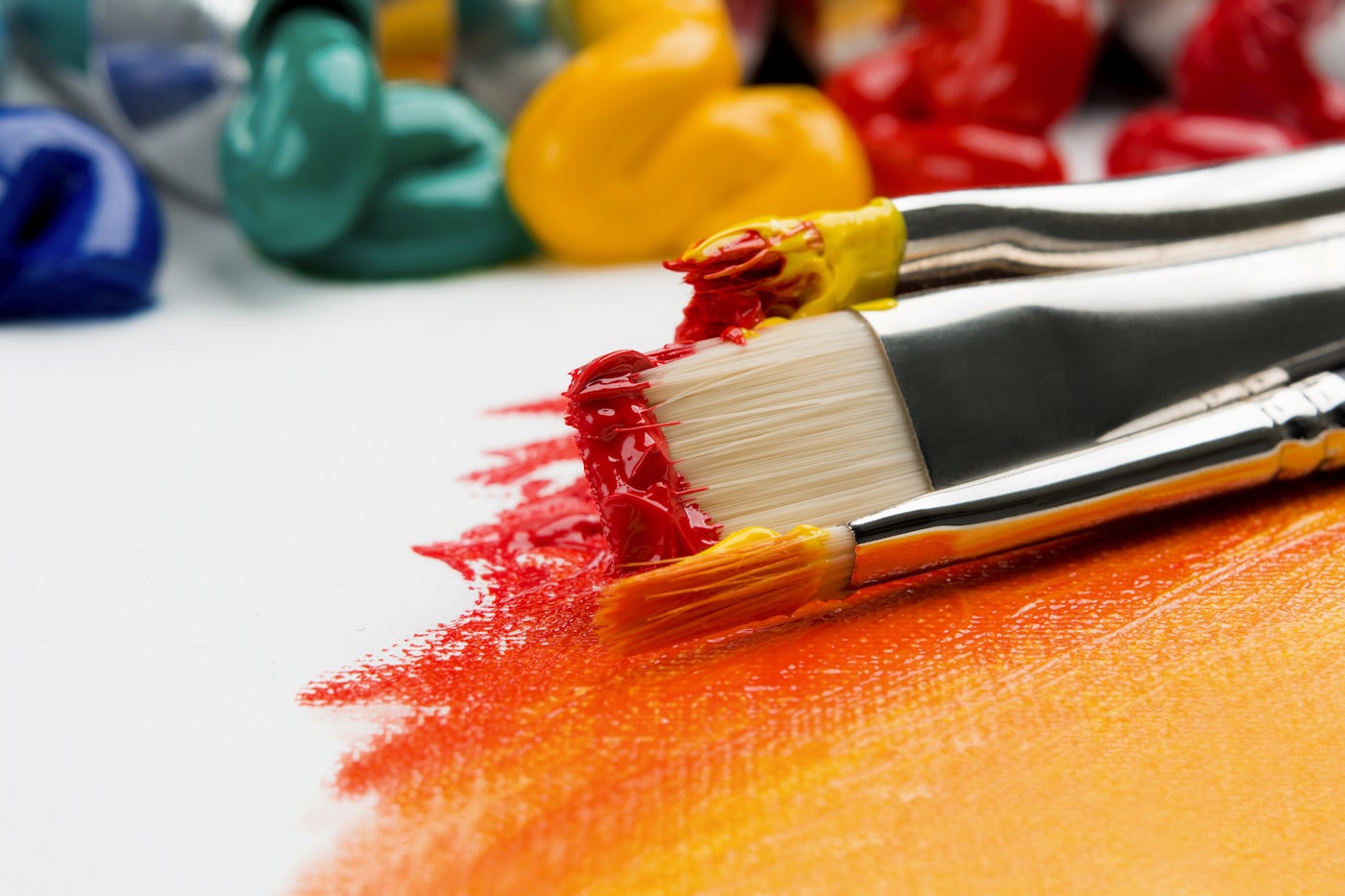 Tavolo con colori, carta e materiali aperti da atelier
